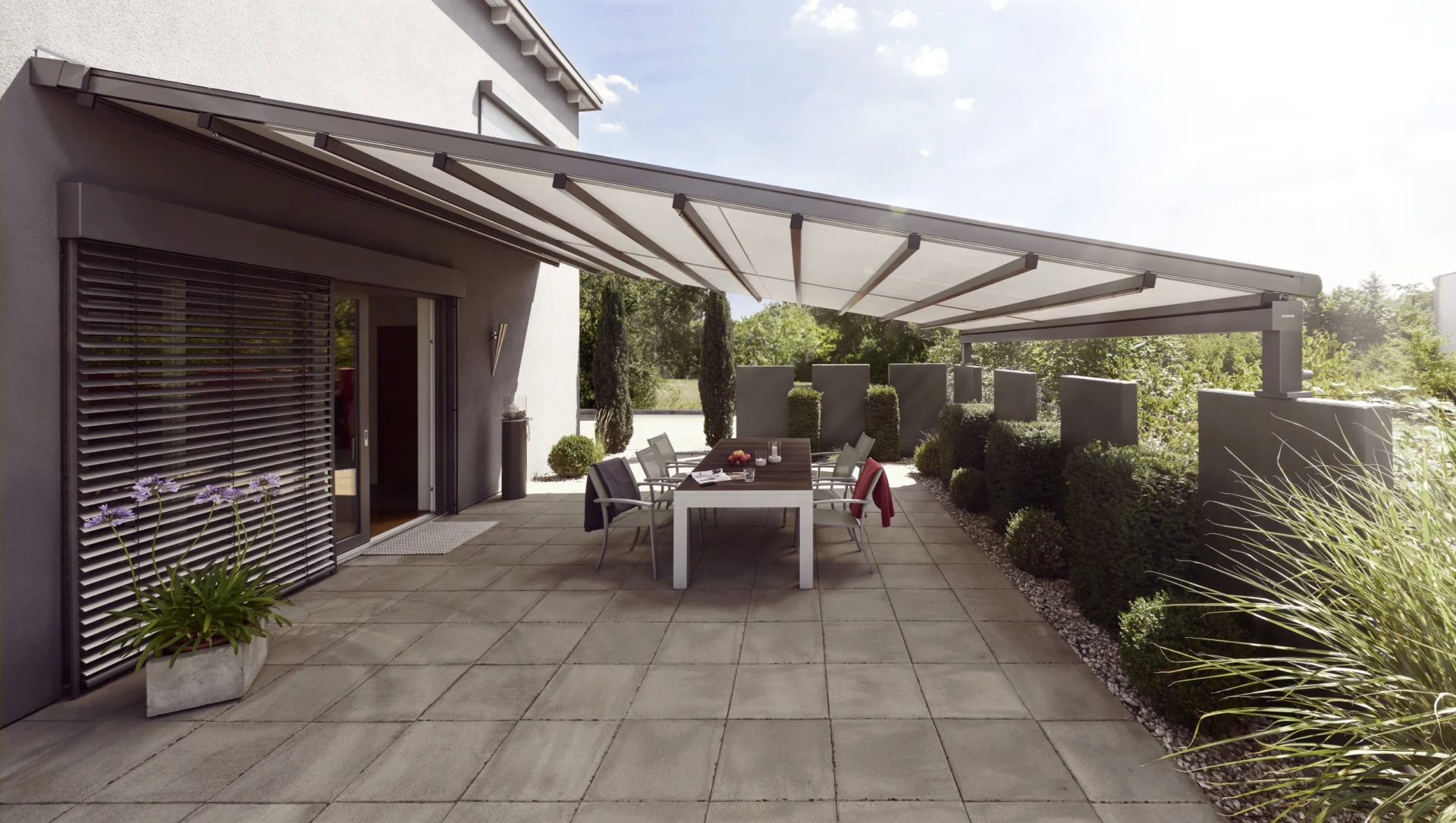 Moderne Terrasse mit Markise und Gartenmöbeln